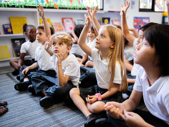Primary School Children Sitting On The Carpet In Class