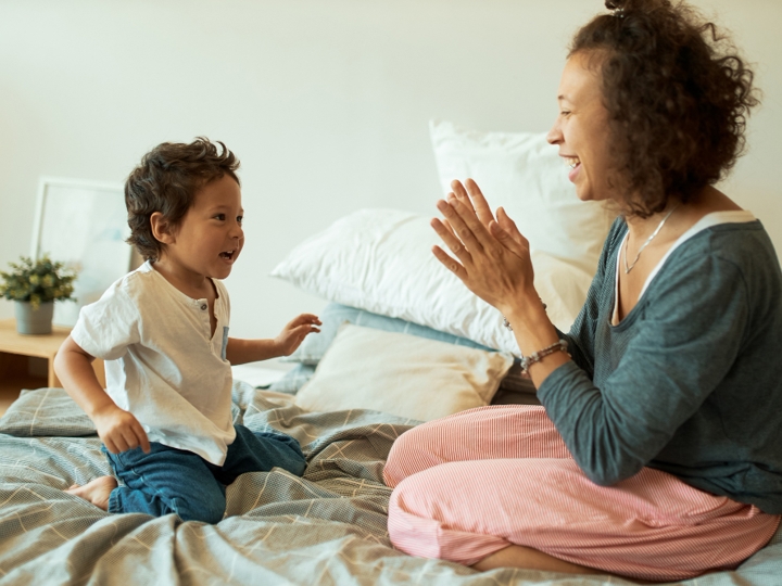 Mum And Son Both Sitting On A Bed