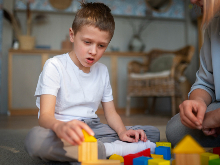 Mum Playing With Her Son On The Floor With Toy Blocks