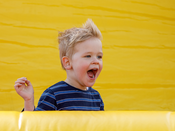 Child screaming happily on a an inflatable slide.