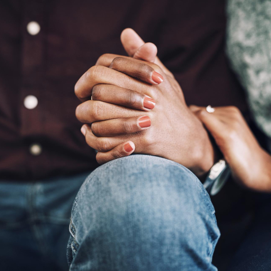 Close up of male and female holding hands