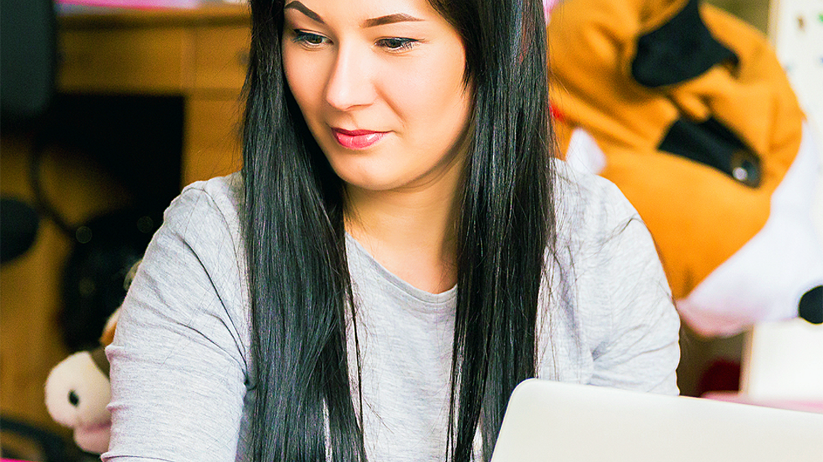 Woman sitting down looking at a laptop